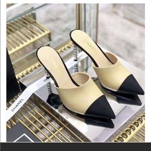 Chanel lambskin leather mules feature a pointed black grosgrain cap toe.